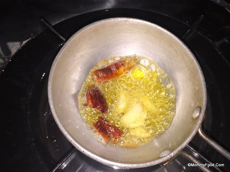 Adding dry red chilli and garlic to the hot ghee