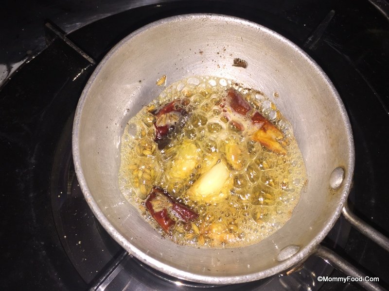 Adding mustard seeds and cumin seeds to the tempering