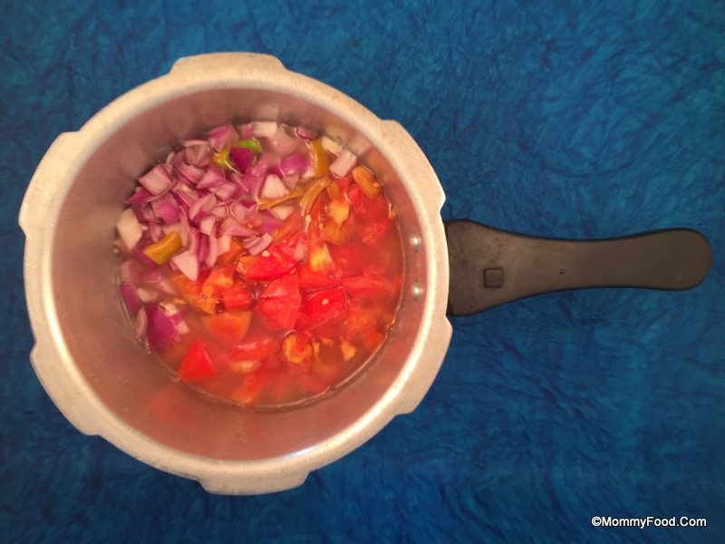 Cooking red gram with tomatoes and onions in a pressure cooker