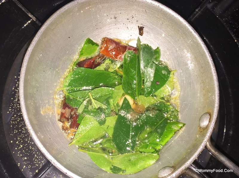 Adding curry leaves and asafoetida to the tempering