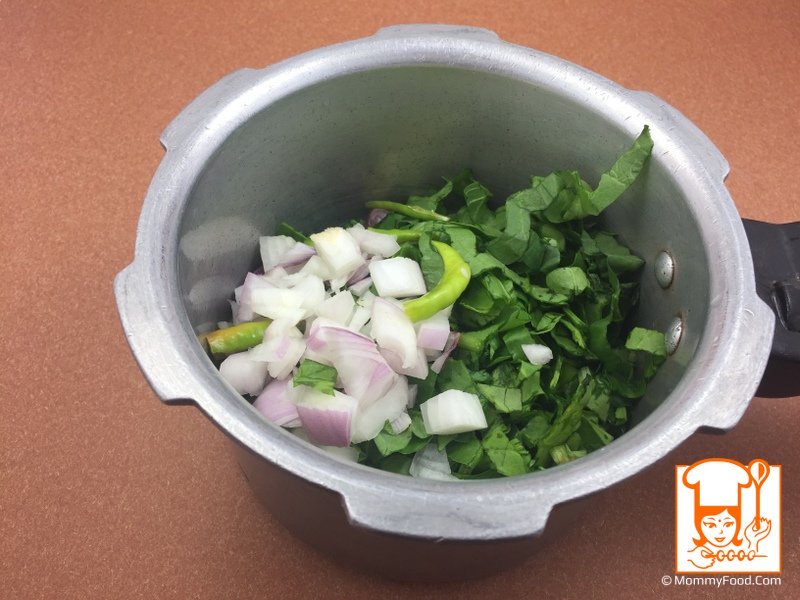 Adding chopped spinach, onions, and green chillies to the pressure cooker