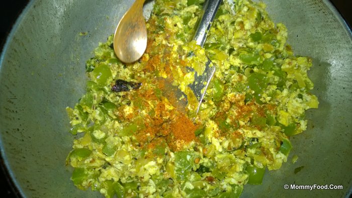 Adding red chilli powder to the curry