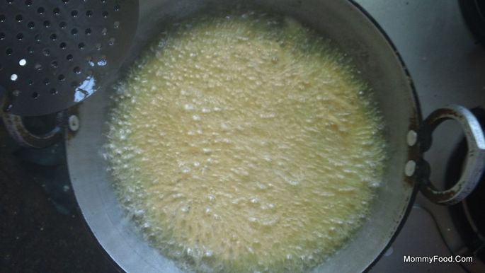 Draining excess oil from fried Kaaram Poosa